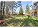 Expansive backyard featuring a large grassy area, a fire pit, and a wooden fence, ideal for outdoor enjoyment at 6065 Nw Gentlewind Court Nw Ct, Powder Springs, GA 30127