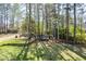 Expansive backyard with mature trees, a trampoline, and a cozy fire pit area at 6065 Nw Gentlewind Court Nw Ct, Powder Springs, GA 30127