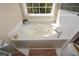 Inviting bathroom featuring a jacuzzi tub beneath a window, creating a relaxing oasis at 6065 Nw Gentlewind Court Nw Ct, Powder Springs, GA 30127