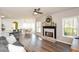 Open-concept living room with hardwood floors and fireplace flowing seamlessly into the dining area and kitchen at 6065 Nw Gentlewind Court Nw Ct, Powder Springs, GA 30127