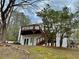 Backyard featuring a spacious deck accessible via wooden stairs, surrounded by mature trees at 89 Paces Lakes Pt, Dallas, GA 30157
