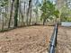 Spacious backyard featuring a black chain link fence, surrounded by mature trees at 89 Paces Lakes Pt, Dallas, GA 30157
