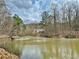 Picturesque view of a pond, with the house nestled among the trees in the background at 89 Paces Lakes Pt, Dallas, GA 30157