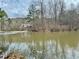 Tranquil view of the pond, with the house nestled amidst the trees in the background at 89 Paces Lakes Pt, Dallas, GA 30157