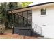 A screened-in sunroom featuring black trimming around the large bay windows, providing a bright, relaxing living space at 1570 Childress Sw Dr, Atlanta, GA 30311