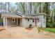 Side view of the gray split level home with a carport and walkway leading to the red front door at 3436 Misty Valley Rd, Decatur, GA 30032