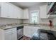 Kitchen with granite countertops, white cabinets, stainless steel dishwasher and black oven/stovetop at 3436 Misty Valley Rd, Decatur, GA 30032