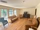 Spacious living room features hardwood floors, two tan sofas, an accent chair and large windows at 5169 Covington Hwy, Decatur, GA 30035
