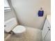 A simple bathroom featuring a white toilet, tiled flooring, and a small vanity at 5470 Chanterella Sw Ct, Lilburn, GA 30047
