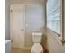 This bathroom features a toilet and a window at 5470 Chanterella Sw Ct, Lilburn, GA 30047