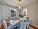 Well-lit dining room with a modern table, stylish chairs, and a view to the kitchen at 5470 Chanterella Sw Ct, Lilburn, GA 30047