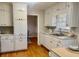 Bright kitchen with ample white cabinetry and hardwood floors, flowing into the dining area at 5470 Chanterella Sw Ct, Lilburn, GA 30047