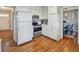 Cozy kitchen with white cabinets and hardwood floors, adjoining a dining area at 5470 Chanterella Sw Ct, Lilburn, GA 30047