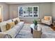 Inviting living room with large window, plush seating, and stylish decor at 5470 Chanterella Sw Ct, Lilburn, GA 30047