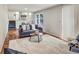 Well-lit living room with open staircase, modern sofa, and stylish area rug at 5470 Chanterella Sw Ct, Lilburn, GA 30047