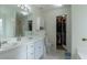 Bathroom featuring double sinks, a big mirror, and a walk-in closet at 10 Flowers Dr, Covington, GA 30014