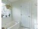 Bathroom featuring a tub, tile floor, and window with plants at 10 Flowers Dr, Covington, GA 30014