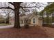 Back view of a ranch-style home featuring a lush, wooded backyard and stone facade accents at 10 Flowers Dr, Covington, GA 30014