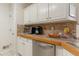 Traditional kitchen design featuring white cabinets, wood countertops, and stainless steel dishwasher at 10 Flowers Dr, Covington, GA 30014