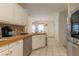 Bright kitchen with tile flooring, white cabinets, stainless appliances, and a view of the dining area at 10 Flowers Dr, Covington, GA 30014