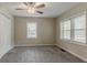 This carpeted bedroom features a ceiling fan and two windows at 1248 W Ridge Ave, Stone Mountain, GA 30083