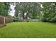 Large, green backyard surrounded by a wooden fence and mature trees at 2344 Johnson Ferry Ne Rd, Atlanta, GA 30341