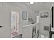 Hallway view to the bathroom and storage with decor art and neutral color scheme at 2344 Johnson Ferry Ne Rd, Atlanta, GA 30341