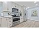 Bright kitchen featuring stainless steel appliances, white cabinets and countertops with a light blue backsplash at 2535 Judson Ave, East Point, GA 30344