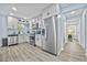 Modern kitchen with stainless steel appliances, white cabinets, gray backsplash, and wood-style flooring at 2535 Judson Ave, East Point, GA 30344