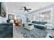 Bright living room with a modern blue sofa, stylish rug, and plenty of natural light from the large window at 2535 Judson Ave, East Point, GA 30344