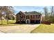 Well-maintained brick home with a spacious driveway and lush green lawn at 4244 Old House Dr, Conley, GA 30288