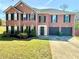Charming two-story brick home featuring a well-manicured lawn and attached two-car garage at 4244 Old House Dr, Conley, GA 30288