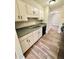 Well-lit kitchen featuring white cabinets, stainless steel appliances, and wood-look tile flooring at 5050 Martins Crossing Rd, Stone Mountain, GA 30088