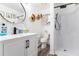 Modern bathroom featuring a round mirror, geometric wall decor, and a sleek white vanity with black hardware at 813 Ridgefield Dr, Peachtree City, GA 30269