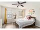 Bright bedroom with two windows, wood-look floors, and playful space-themed wall decor at 813 Ridgefield Dr, Peachtree City, GA 30269