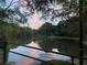 Beautiful view of a tranquil pond reflecting the sky, surrounded by mature trees and lush greenery at 813 Ridgefield Dr, Peachtree City, GA 30269