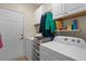 Convenient laundry room includes a washer, dryer, storage shelves, and utility sink at 2130 Birkdale St, Villa Rica, GA 30180
