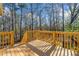 A spacious deck surrounded by trees offers serene outdoor living at 9061 Greenwood Way, Canton, GA 30115