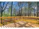 A wooden deck features railings, offering a cozy space to enjoy nature at 9061 Greenwood Way, Canton, GA 30115