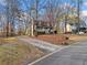 A charming home boasts a spacious driveway and lush, mature landscaping at 9061 Greenwood Way, Canton, GA 30115
