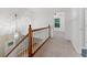 Bright hallway featuring wood railing, chandelier lighting, and neutral carpet at 9061 Greenwood Way, Canton, GA 30115