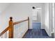 Upstairs hallway with blue carpet and door to bedroom at 9061 Greenwood Way, Canton, GA 30115