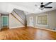 Open living area featuring hardwood floors and staircase, filled with natural light from a large window at 9061 Greenwood Way, Canton, GA 30115