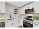 Bright kitchen boasts stainless steel appliances, sleek white cabinetry, and modern countertops at 2115 Randolph Nw Cir, Kennesaw, GA 30144