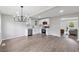 Open concept kitchen with stainless appliances, white cabinets, modern lighting, and expansive wood floors at 2115 Randolph Nw Cir, Kennesaw, GA 30144