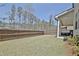 A spacious backyard featuring a wood fence, grassy area, and a covered patio for outdoor enjoyment at 516 Cunninghame Ct, Peachtree City, GA 30269