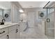 Bright bathroom featuring marble flooring, dual vanities with black fixtures, and a walk-in shower at 516 Cunninghame Ct, Peachtree City, GA 30269
