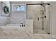 Bathroom featuring a soaking tub, glass shower with marble-style tiles, and a window at 516 Cunninghame Ct, Peachtree City, GA 30269
