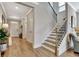 Hallway with hardwood floors, staircase, and access to the front door offering a welcoming entrance at 516 Cunninghame Ct, Peachtree City, GA 30269