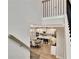 Open-concept kitchen with a central island, dining table, and light wood floors viewed from the staircase landing at 516 Cunninghame Ct, Peachtree City, GA 30269